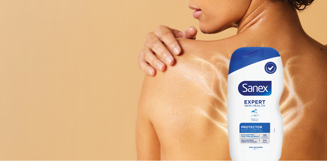 Femme de dos, peau mouillée, à côté d'un gel douche portant l'inscription « expert skin health » au premier plan, sur fond vert-orange.